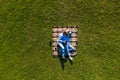 Top view of young couple lying on the blanket on green grass holding photo camera and watching photos. View from above Royalty Free Stock Photo