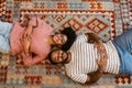 Top view of young couple smiling while laying on carpet at home Royalty Free Stock Photo