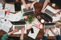 Top view of young coworking people are working on laptops and paper documents. Group of college students using laptop while sittin Royalty Free Stock Photo