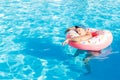 Top view of young drunk guy swim with pink circle in pool. drunk guy on vacation in the hotel