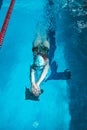 Top view of a young female swimmer training in the pool, swimming on her back underwater. Floats under water and blows Royalty Free Stock Photo