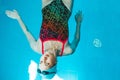 Top view of a young female swimmer training in the pool, swimming on her back underwater. Floats under water and blows Royalty Free Stock Photo