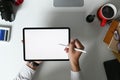 Top view of young graphic designer using stylus pen writing on tablet with white screen. Royalty Free Stock Photo