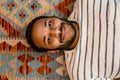 Top view of indian man smiling while laying on carpet at home Royalty Free Stock Photo