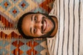 Top view of indian man smiling while laying on carpet at home Royalty Free Stock Photo