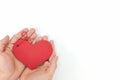 Top view of young male cupped hands holding a red heart shape tag in white background. Non-materialistic love is the best gift.