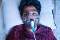 Top View of young man breathing on ventilator or oxygen concentrator mask at hospital due coronavirus covid-19 dyspnea or