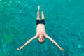 Top view of a young man floating in swimming pool with open arms Royalty Free Stock Photo