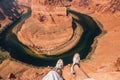 Top view of a young man sitting by the edge of the cliff at the Horse Shoe Bend at the Grand Canyon Royalty Free Stock Photo