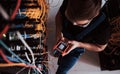 Top view of young man in uniform with measuring device that works with internet equipment and wires in server room Royalty Free Stock Photo