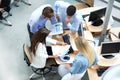 Top view of young modern colleagues in smart casual wear working together while spending time in the office.