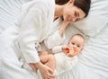 Top view, young mother hugging her baby lying on the bed together Royalty Free Stock Photo