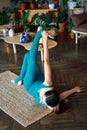 Top view of young sporty woman practicing stretching exercise doing one armed swastikasana yoga pose