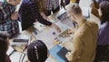 Top view of young team working on architectural project. Group of mixed race people standing near table and discussing. Royalty Free Stock Photo