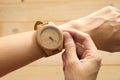 Top view. young woman equip wooden wrist watch on her arm and ch Royalty Free Stock Photo