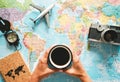 Top view of young woman planning her vacation using world map while drinking coffee - Tourist pointing the next travel destination