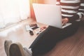 Top view of young woman sitting on floor with laptop, Laptop in girl`s hands sitting on a wooden floor Royalty Free Stock Photo