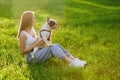 Female dog owner holding french bulldog on knees outdoors. Royalty Free Stock Photo