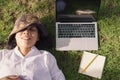 Top view, young woman of smiling while lying on green grass in a public park, Laptop, Notebook, Pencil,  Lifestyle business Royalty Free Stock Photo