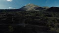 Top view of a young woman walks towards Batur volcano, Bali, on black lava.