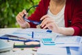 Top view of young working woman using laptop and reading annual report document at work. Business woman working at her desk Royalty Free Stock Photo