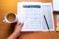 Top view of young working woman using laptop and reading annual report document at work. Business woman working at her desk Royalty Free Stock Photo