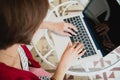 Top view of young working woman using laptop and reading annual report document at work. Business woman working at her desk Royalty Free Stock Photo