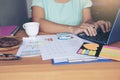 Top view of young working woman using laptop and reading report , graphs , charts, document at work. Royalty Free Stock Photo