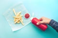 Top view of youngman squeezing a bottle sauce ketchup for dipping with french fried on blue color background