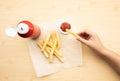 Top view of youngwoman dipping french fried  with tomato sauce  ketchup  on wood table background Royalty Free Stock Photo