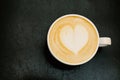 Top viewof big cup of freshly brewed cappuccino with soft foam and heart on wooden table Royalty Free Stock Photo