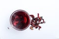 Top view of glass cup of hot hibiscus tea and dried petals on the white surface Royalty Free Stock Photo