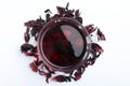 Top viewof glass cup of red hibiscus tea ad petals on the white background Royalty Free Stock Photo