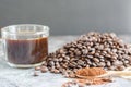 Coffee in wooden spoon and fresh roasted coffee beans with a cup of hot coffee on top of stone background Royalty Free Stock Photo