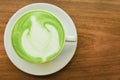 Top viwe. Milk green tea latte in cup on wood