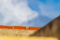 The top of the wall against the background of a cloudy sky, the upper level of which is lined with red brick, as the Royalty Free Stock Photo