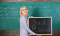 Top ways to welcome students back to school. Teacher woman hold blackboard inscription back to school. It is school time Royalty Free Stock Photo