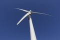 Top of windmill viewed from below with daytime moon in blue sky Royalty Free Stock Photo