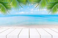 Top of wood table with seascape and palm leaves, blur bokeh light of calm sea and sky at tropical beach background.blurred blue Royalty Free Stock Photo