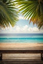 Top of wood table with seascape and palm leaves, blur bokeh light of calm sea and sky at tropical beach background. Empty ready fo Royalty Free Stock Photo