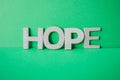 Tope view of wooden letters on the green backgrounds writing the word hope with capital letters