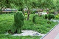 Topiary bushes in the form of a lion and a panther in a city park.