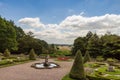 Topiary, flower beds and small fountain in a formal garden in a park in Cheshire, UK. Royalty Free Stock Photo