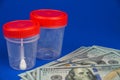 The topic is the cost of a medical examination. Close-up of American dollar banknotes and plastic containers for collecting analyz