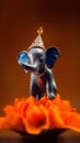 A tiny elephant balancing on the tip of a bright orange flower Royalty Free Stock Photo