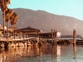 Topical landscape, sea, mountains, bungalows, bridge and palm trees on summer beach Royalty Free Stock Photo