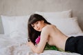 topless. an attractive and sexy woman with a bouquet of peonies lies in bed. Royalty Free Stock Photo