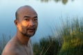 Topless bald beard Asia man with outdoor lake nature background
