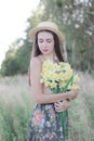 topless brunette woman in straw hat covering her breasts with flowers in the field Royalty Free Stock Photo