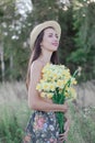 topless brunette woman in straw hat covering her breasts with flowers in the field Royalty Free Stock Photo
